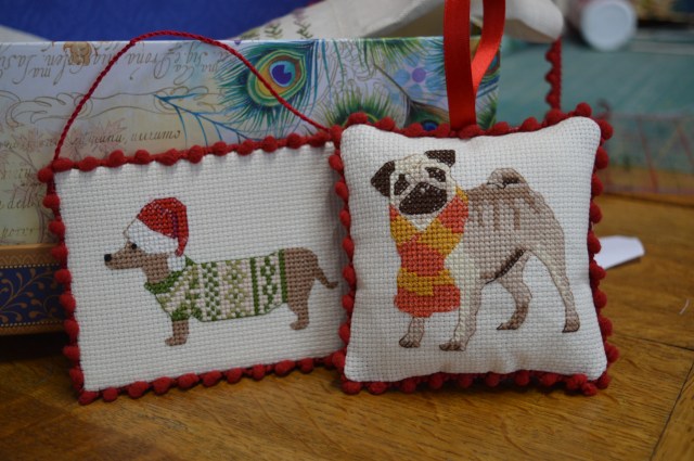 A Christmas dachshund and a cute pug in cross-stitch